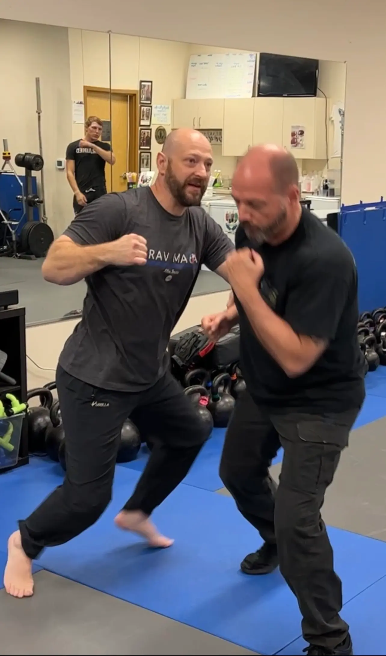 A chief instructor demonstrating self-defense techniques with a student during a training session.